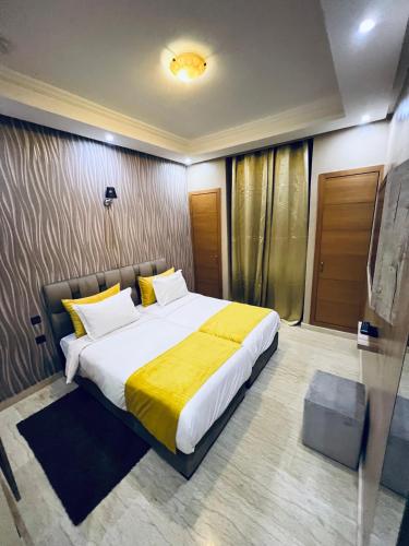 a bedroom with a large bed with a yellow blanket at Villa de luxe à marrakech in Marrakech