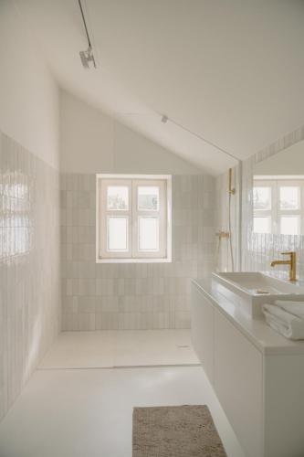 a white bathroom with a sink and a mirror at APARTAMENT OSIEM OSIEM w CENTRUM in Nowy Sącz