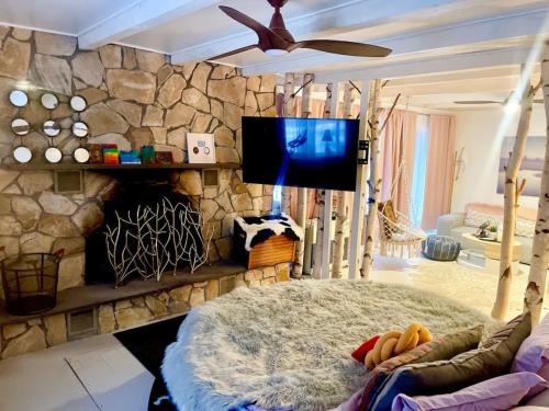a living room with a tv and a rock wall at Guest Favorite Garuda Apartment 8 in Shandaken