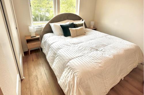 Un dormitorio con una gran cama blanca con almohadas. en Bay View Loft, en Lincoln City