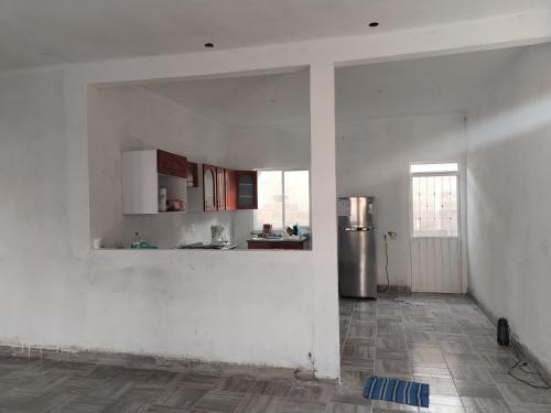 a kitchen with white walls and a stainless steel refrigerator at Renta de casa en Yautepec in Oacalco