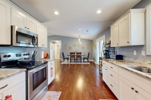 a kitchen with white cabinets and a wooden floor at Blueridge Brew View in Fairview
