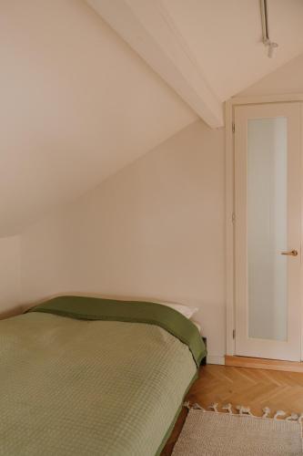 una camera con un letto verde di APARTAMENT OSIEM OSIEM w CENTRUM a Nowy Sącz