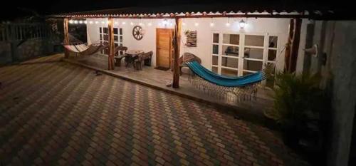 a porch of a house with a hammock on it at The Summer House Ayangue in Ayangue