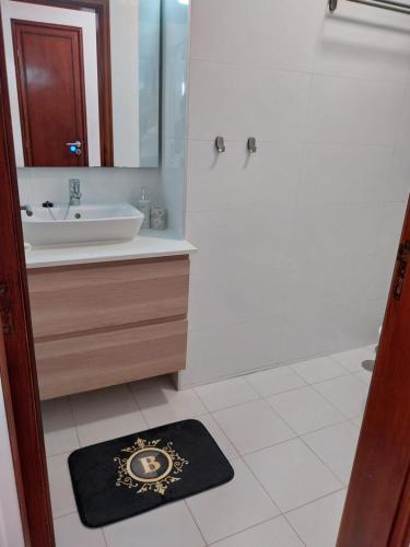 a bathroom with a sink and a mirror and a rug at Buddies Charm House in Aveiro