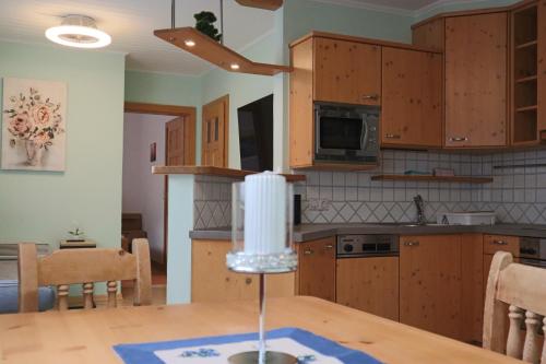 a kitchen with wooden cabinets and a table with a candle at Landhaus-Appartements Warraich in Schladming