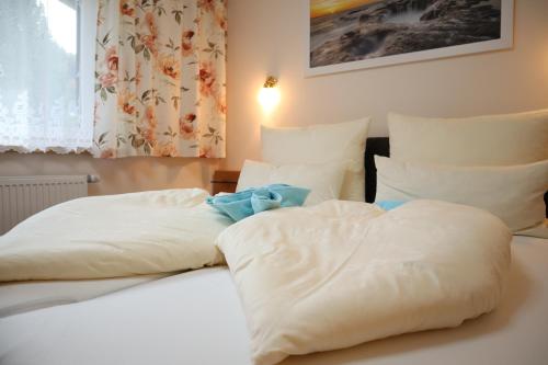 a white bed with a blue teddy bear on it at Landhaus-Appartements Warraich in Schladming
