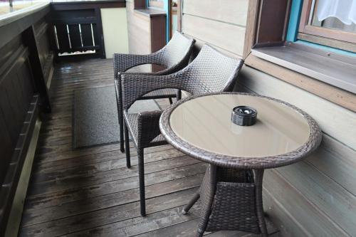 two chairs and a table on a porch at Landhaus-Appartements Warraich in Schladming