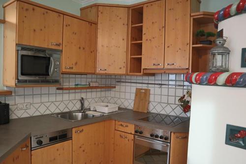 a kitchen with wooden cabinets and a sink at Landhaus-Appartements Warraich in Schladming