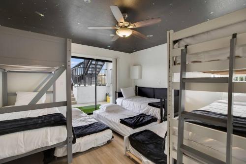three bunk beds in a room with a ceiling fan at Lux Fun Zone Home - Sleeps 16 in Mesa