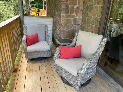 two chairs with red pillows sitting on a porch at A Slice of High Country Heaven, Seven Devils Condo in Seven Devils