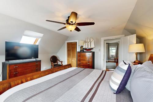 a bedroom with a large bed and a ceiling fan at Snug Harbor II in Boothbay Harbor