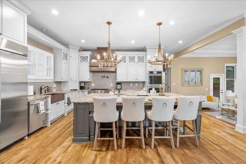 a kitchen with white cabinets and a island with bar stools at 11580sqft Large Home By Airport in Atlanta