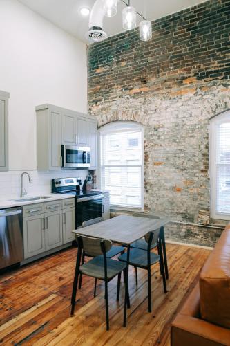 a kitchen with a table and chairs and a brick wall at The St. Clair in Frankfort