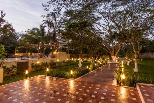 a garden at night with lights in the grass at Hacienda Santa Cruz Merida in Mérida