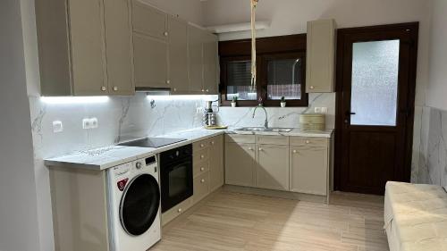 a kitchen with a washing machine and a sink at Hermione's house in Vrontados