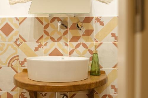 a bathroom with a white sink on a wooden table at Sud Est 13 in Putignano