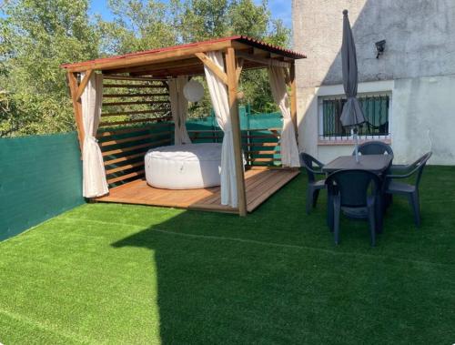 un gazebo sur une pelouse avec une table et des chaises dans l'établissement L escapade nature, à Saint-Brès