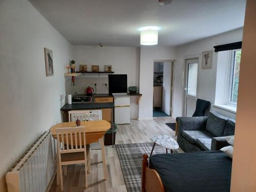 a living room with a couch and a table at Cosy Garden Flat near Bay & City Centre - Fast Wifi, 5 mins to centre in Cardiff