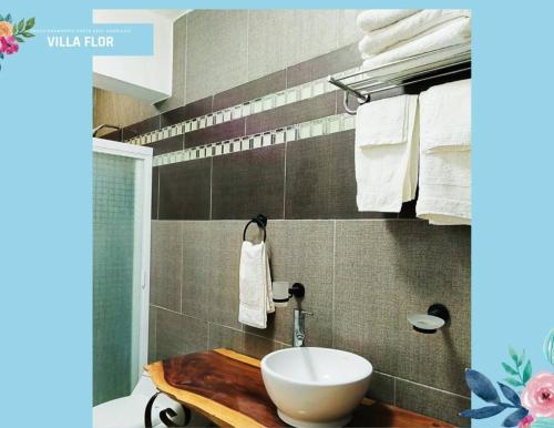 y baño con lavabo, aseo y toallas. en Villa Flor Acapulco, en Acapulco
