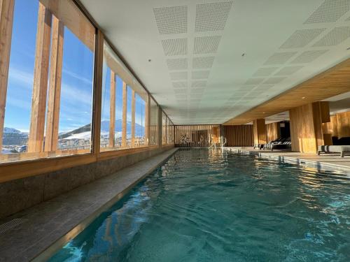 - une piscine dans un bâtiment avec fenêtres dans l'établissement Alpe d'Huez Houses - Alpe Forever - PHOENIX3 - 3 chambres 5 étoiles pour 6 à 8 skis aux pieds, à L'Alpe-d'Huez