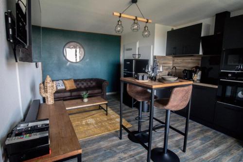 Il comprend une petite cuisine et un salon avec une table et un canapé. dans l'établissement Logement Cosy, Climatisé, à Toulouse