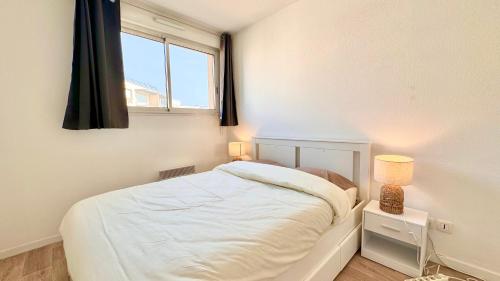 une chambre avec un lit blanc et une fenêtre dans l'établissement Logement lumineux 10min Disney, à Montévrain