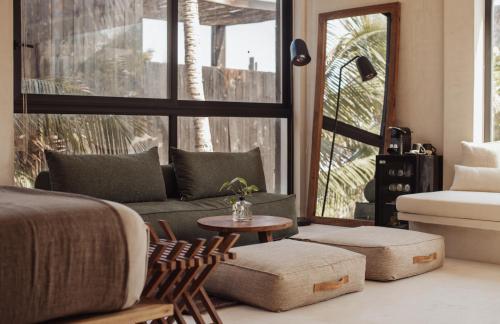 a bedroom with a bed and a couch and a table at UMi Tulum in Tulum