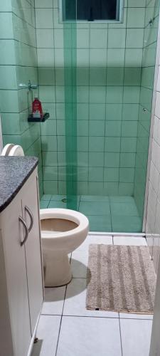 a bathroom with a toilet and a green shower at Apto Completo Aparecida de Goiânia in Aparecida de Goiânia