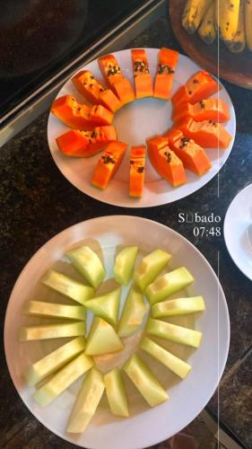 two plates of food with apples and carrots on them at La Luna dos Pireneus - Pousada in Pirenópolis