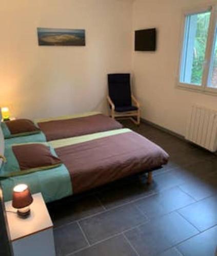 une chambre avec un lit et une chaise dedans dans l'établissement Villa avec Jacuzzi, Lac, océan, plages Arcachon, à La Teste-de-Buch