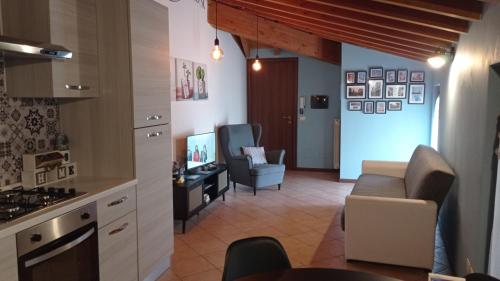 a kitchen and a living room with a couch at Il Fante di Picche in Verolanuova