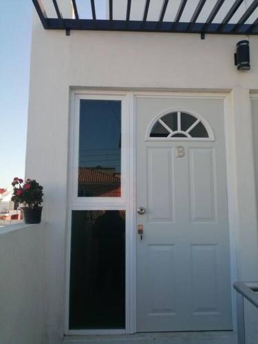 a white door with a window on a white house at Departamento Ciudad del Valle B in Tepic