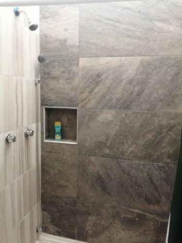 a bathroom with a shower with a large stone wall at Departamento Ciudad del Valle B in Tepic