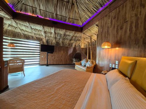 a bedroom with a bed and a tv in a room at Thai Lagoon in Laurel de Lagunillas