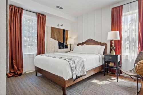 a bedroom with a large bed with red curtains at Peri Social House in Black Mountain