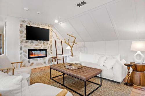 a living room with white furniture and a fireplace at Peri Social House in Black Mountain
