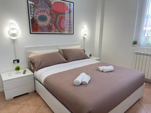 een slaapkamer met een bed met twee handdoeken erop bij 10' Malpensa Airport, alongside Train Station in Casorate Sempione