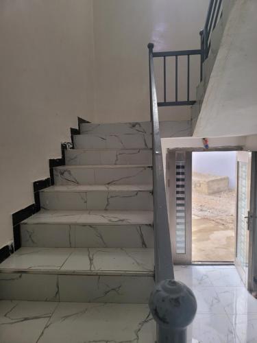 a staircase in a room with a window and a stair case at La Holland in Toubab Dialaw