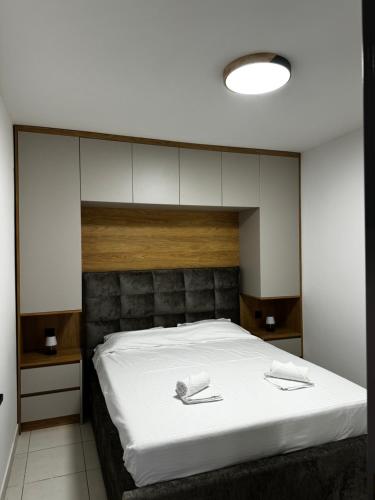a bedroom with a large bed with white sheets at Lakeside house in Podgorica