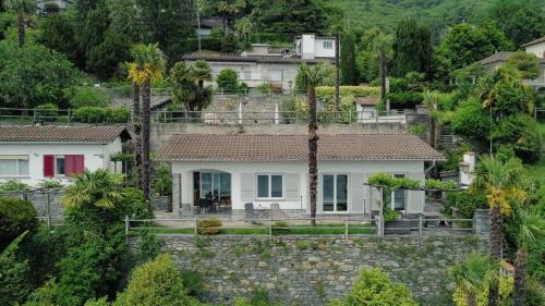 a house on a hill with palm trees at Casa Rondinella App 9500 in Orselina