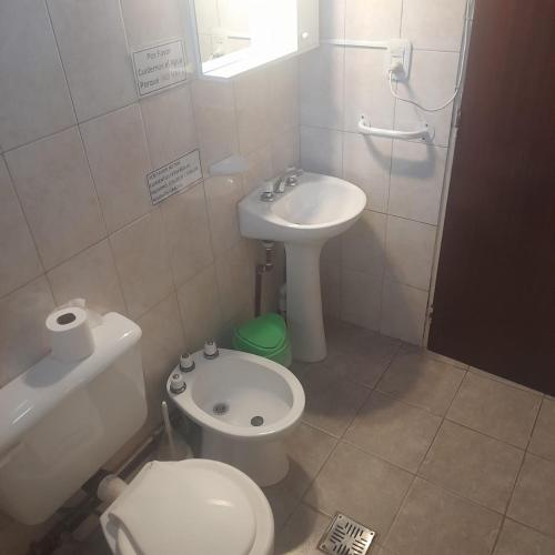 a small bathroom with a toilet and a sink at La Normita cabañas in Potrerillos