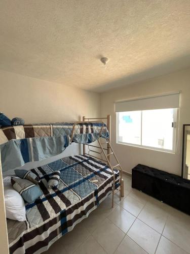 ein Schlafzimmer mit Etagenbett und Fenster in der Unterkunft Cómodo depto Cerca al mar y cerca de Aeropuerto in Gallinero