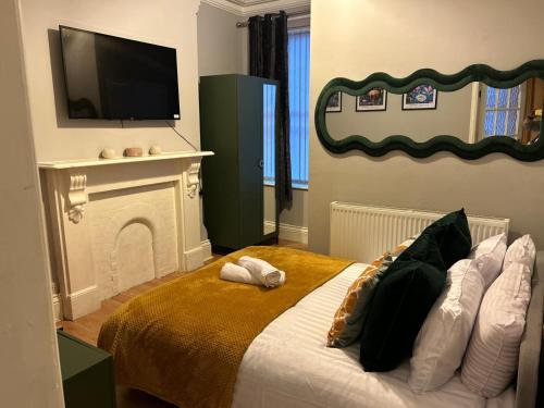a bedroom with a bed with a fireplace and a flat screen tv at Flat 1 in Nottingham