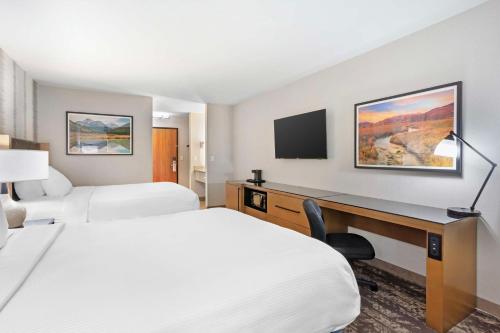 a hotel room with two beds and a desk at Best Western Holiday Hills in Coalville