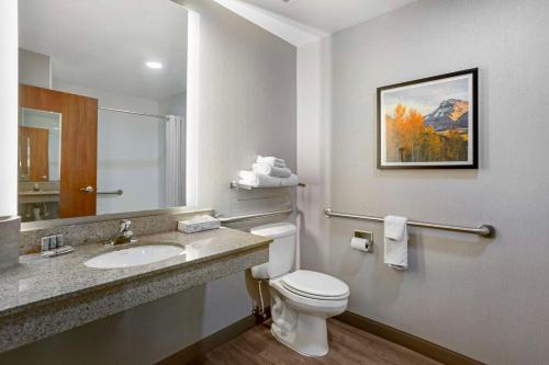 a bathroom with a toilet and a sink and a mirror at Best Western Holiday Hills in Coalville