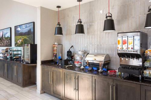 a kitchen with stainless steel counter tops and black pendant lights at Best Western Holiday Hills in Coalville