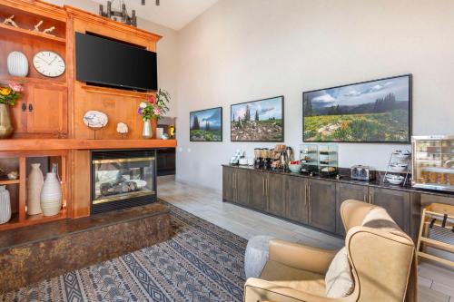 a living room with a fireplace and a flat screen tv at Best Western Holiday Hills in Coalville