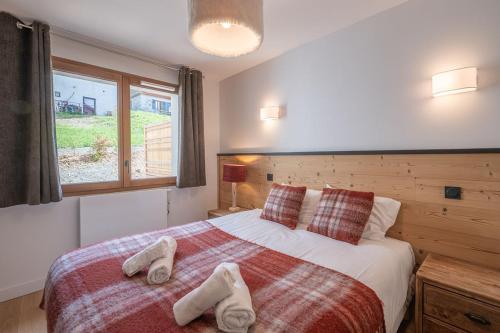 - une chambre avec un lit et 2 paires de chaussons dans l'établissement Chez Lydia - 104m2 d'espace et de confort pour 6, à L'Alpe-d'Huez