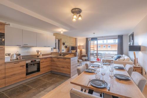 une cuisine et un salon avec une table et des chaises dans l'établissement Chez Lydia - 104m2 d'espace et de confort pour 6, à L'Alpe-d'Huez